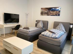 ein Wohnzimmer mit 2 Sofas und einem TV in der Unterkunft Holiday Apartments House in Essen