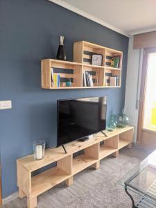 sala de estar con TV de pantalla plana grande en Apartamento en la playa, en Górliz-Elexalde