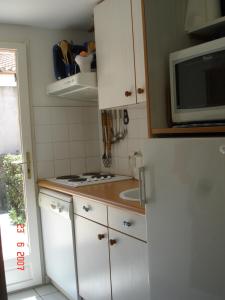 ル・バルカレスにあるMaisons du lacのキッチン(白い冷蔵庫、電子レンジ付)