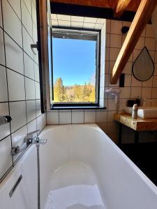 a bath tub in a bathroom with a window at Willa Czaremka in Ujsoły