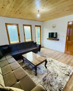 uma sala de estar com um sofá e uma mesa de centro em Villa Troi Rugovë Pejë em Pec