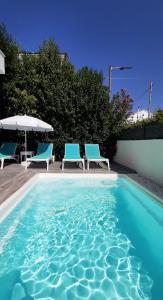 uma piscina com duas cadeiras e um guarda-sol em The Central Villa - Kassiopi Corfu Villas em Kassiopi