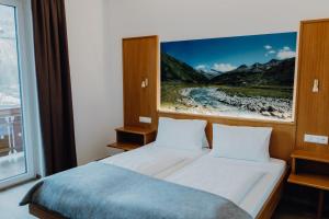 Hotel Restaurant Platzer في غيموند ان كارنتين: غرفة نوم بسرير مع لوحة على الحائط