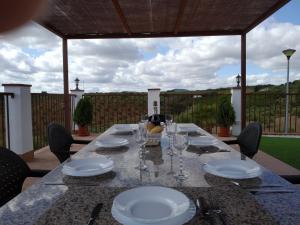 a table with plates and wine glasses on a patio at La sombra del lagarto in Peñaflor