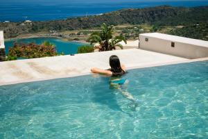 Una donna è seduta in una piscina di Residenza Venus Dream a Pantelleria