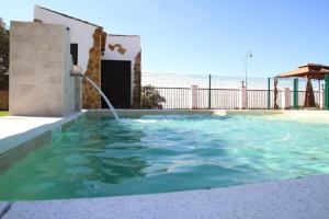 a swimming pool with a water fountain at La sombra del lagarto in Peñaflor +14 photos