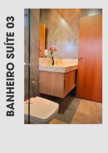 a bathroom with a sink and a toilet and a mirror at Recanto dos três Amores in Olímpia