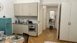cocina con armarios blancos y nevera azul en Kampa park Apartment, en Praga