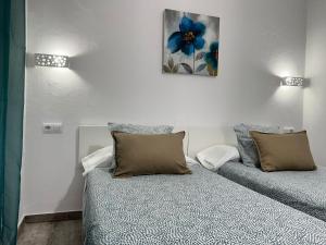 um quarto com uma cama com duas almofadas em Casa Patio Paraíso em Vejer de la Frontera