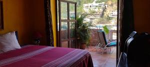 a bedroom with a bed and a door to a balcony at Villas del Amor Amor in Puerto Vallarta