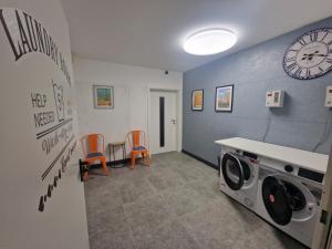 eine Waschküche mit einer Waschmaschine und einer Uhr in der Unterkunft The Ferienwohnung in Bremen