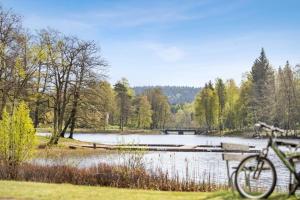 ein Fahrrad, das neben einem See mit einer Brücke geparkt ist in der Unterkunft Route 154, 15 min till Ullared in Älvsered