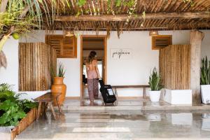 a woman standing in a room with a suitcase at Casa PESQUEIRA Preá - Frente Mar! in Prea