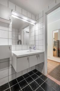 een witte badkamer met een wastafel en een spiegel bij Cozy Cove at Solsiden - 2BR familyfriendly in Trondheim