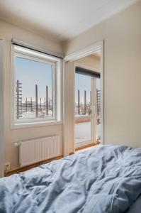 sypialnia z łóżkiem i 2 oknami w obiekcie Cozy Cove at Solsiden - 2BR familyfriendly w mieście Trondheim