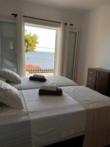 two beds in a bedroom with a view of the ocean at Mediterranean Jewel in Blato +42 photos