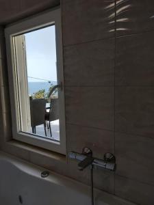 - Baño con espejo, ventana y bañera en Mediterranean Jewel, en Blato