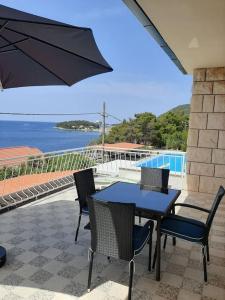a table with chairs and an umbrella on a patio at Mediterranean Jewel in Blato