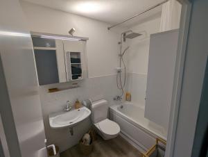 een badkamer met een wastafel, een toilet en een bad bij Wohnung mit Balkon und Aufzug in Hagen