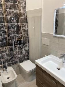 bagno con lavandino, servizi igienici e specchio di Casa Gemelli Roma a Roma