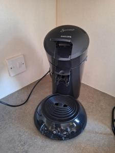 a black espresso machine sitting on the floor at EnJoy Meer und See Ferienhaus -Aan het Lauwersmeer in Lauwersoog -3 Slaapkamers - 1 tot 6 pers -Vanaf 14u al inchecken! Free WIFI! in Lauwersoog