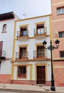 een gebouw met balkons en een straatlampje ervoor bij Vivienda con fines turísticos "Casa Paquita" in Andújar