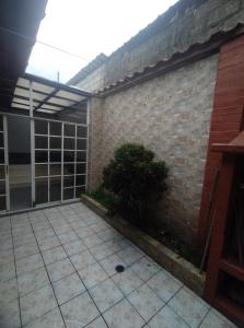 un patio con una pared de ladrillo y una planta en Posada de Zory, en Santo Domingo de los Colorados
