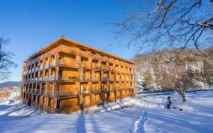 a building in the snow with snow covered ground at The Valley Bakuriani Didveli Apartment 304 in Bakuriani