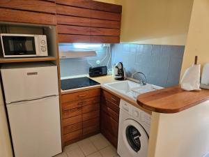 a small kitchen with a white refrigerator and a microwave at Caribbean sea view in Saint-François