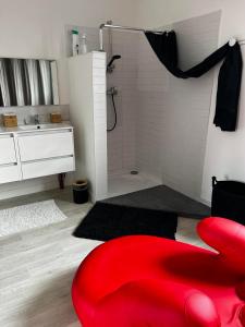 een badkamer met een rode kruk en een douche bij Destination Confidentielle in Clermont-Ferrand