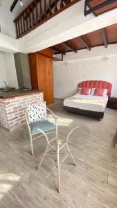 Zimmer mit zwei Stühlen und einem Bett im Hintergrund in der Unterkunft HOTEL CASA BRESSE in Cali