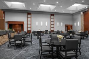 a dining room with tables and chairs and a fireplace at Renaissance Indianapolis North Hotel in Carmel