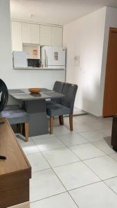 a kitchen with a table and chairs and a refrigerator at Apartamento Cuiabá in Cuiabá