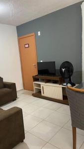 Uma TV ou centro de entretenimento em Apartamento Cuiabá