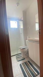 a bathroom with a toilet and a glass shower at Apartamento Cuiabá in Cuiabá