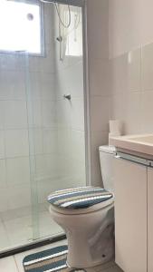 a white bathroom with a toilet and a shower at Apartamento Cuiabá in Cuiabá