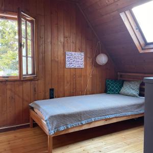 Cama en habitación de madera con ventana en Kleines Waldglück, en Lenzkirch