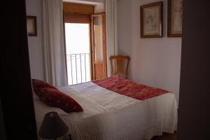 Habitación pequeña con cama y ventana en Apartamento La Luna Mora - A un paso del Caminito del Rey en Carratraca