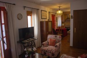 salon z krzesłem i telewizorem w obiekcie Apartamento La Luna Mora - A un paso del Caminito del Rey w mieście Carratraca