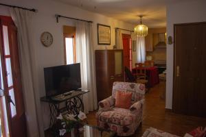 a living room with a chair and a tv at Apartamento La Luna Mora - A un paso del Caminito del Rey in Carratraca