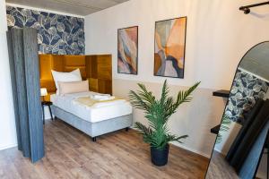 1 dormitorio con 1 cama y una maceta en Svyvo Cologne - Serviced Suites en Colonia