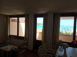 a room with three windows and a table and chairs at Centro Servizi Marinella in Santa Marinella