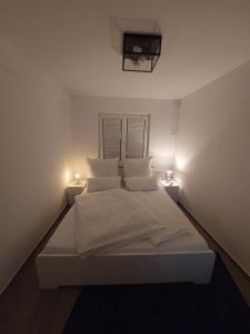 a white bed in a room with two lights at Modern apartment cologne in Cologne