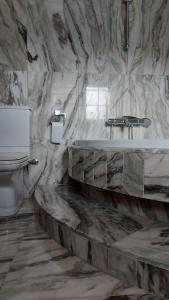 a marble bathroom with a sink and a toilet at Casa en Playa Las Sinas in Villanueva de Arosa +22 photos