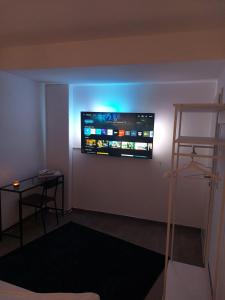Habitación con TV de pantalla plana en la pared en Modern apartment cologne, en Colonia