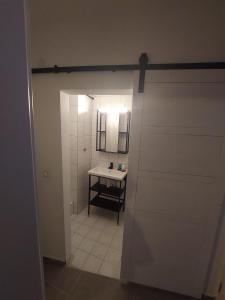 een badkamer met een witte deur en een wastafel bij Modern apartment cologne in Keulen