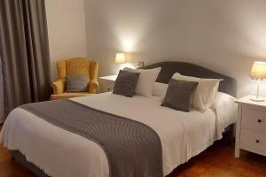 a bedroom with a large bed and a chair at Casa en Playa Las Sinas in Villanueva de Arosa