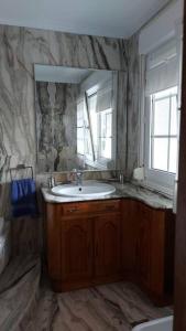 a bathroom with a sink and a mirror at Casa en Playa Las Sinas in Villanueva de Arosa