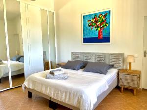 1 dormitorio con 1 cama y una pintura en la pared en Maison La Samana, en Baie-Mahault