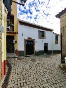 una calle adoquinada con un edificio blanco en Refugio d'Anita Douro Valley House en Barcos